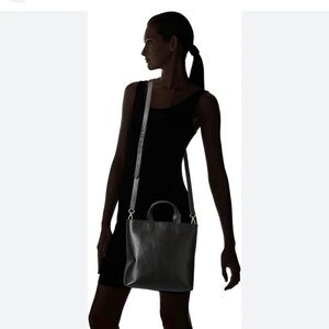 The Zip-Top Transport Crossbody black with gold zipper